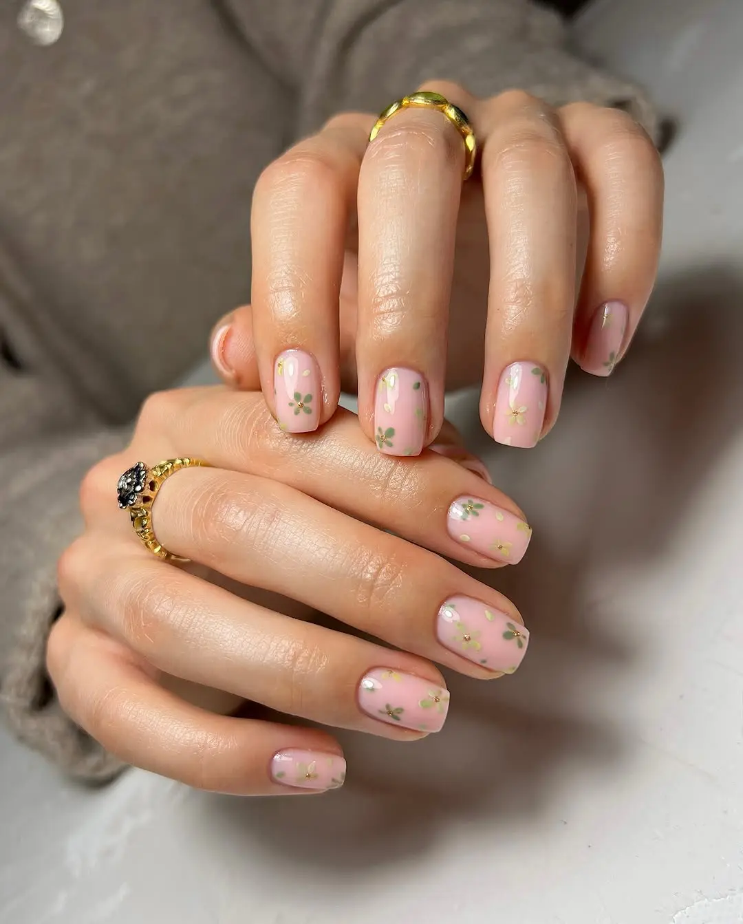 Floral accent nails on pink base, delicate spring design.