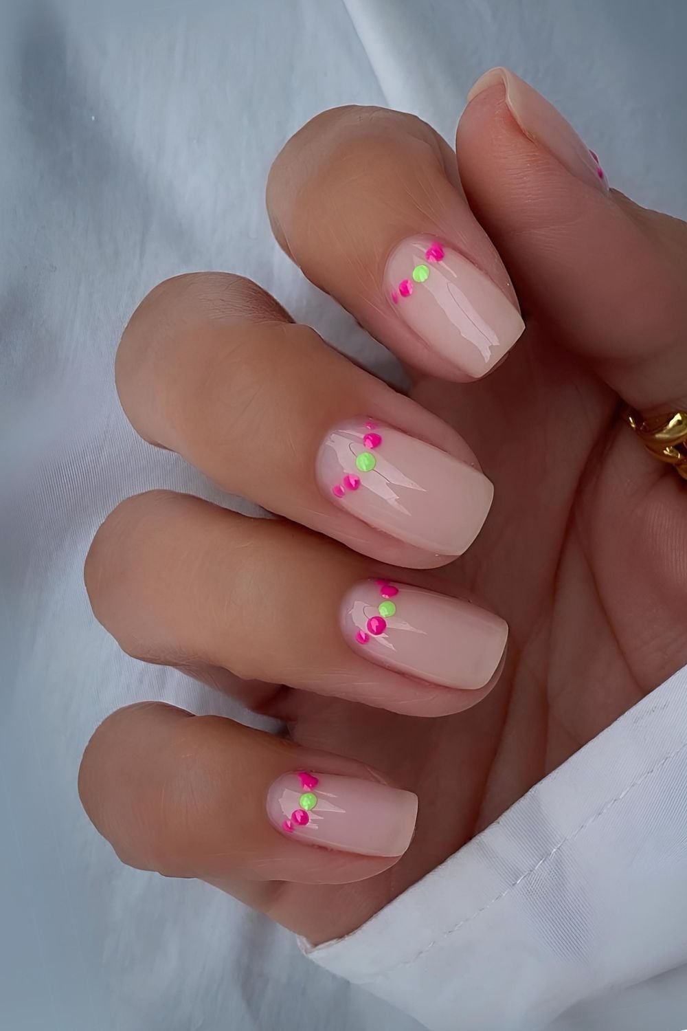 Nude nails with neon dot accents, fun and colorful design.
