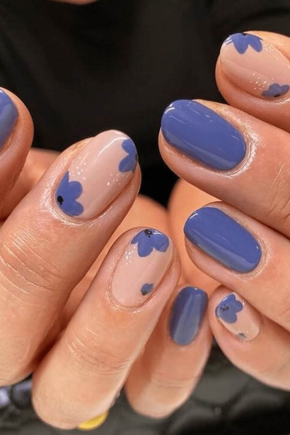 Blue floral nails on nude base, playful and artistic