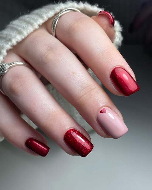 Red nails with heart accent, romantic and bold