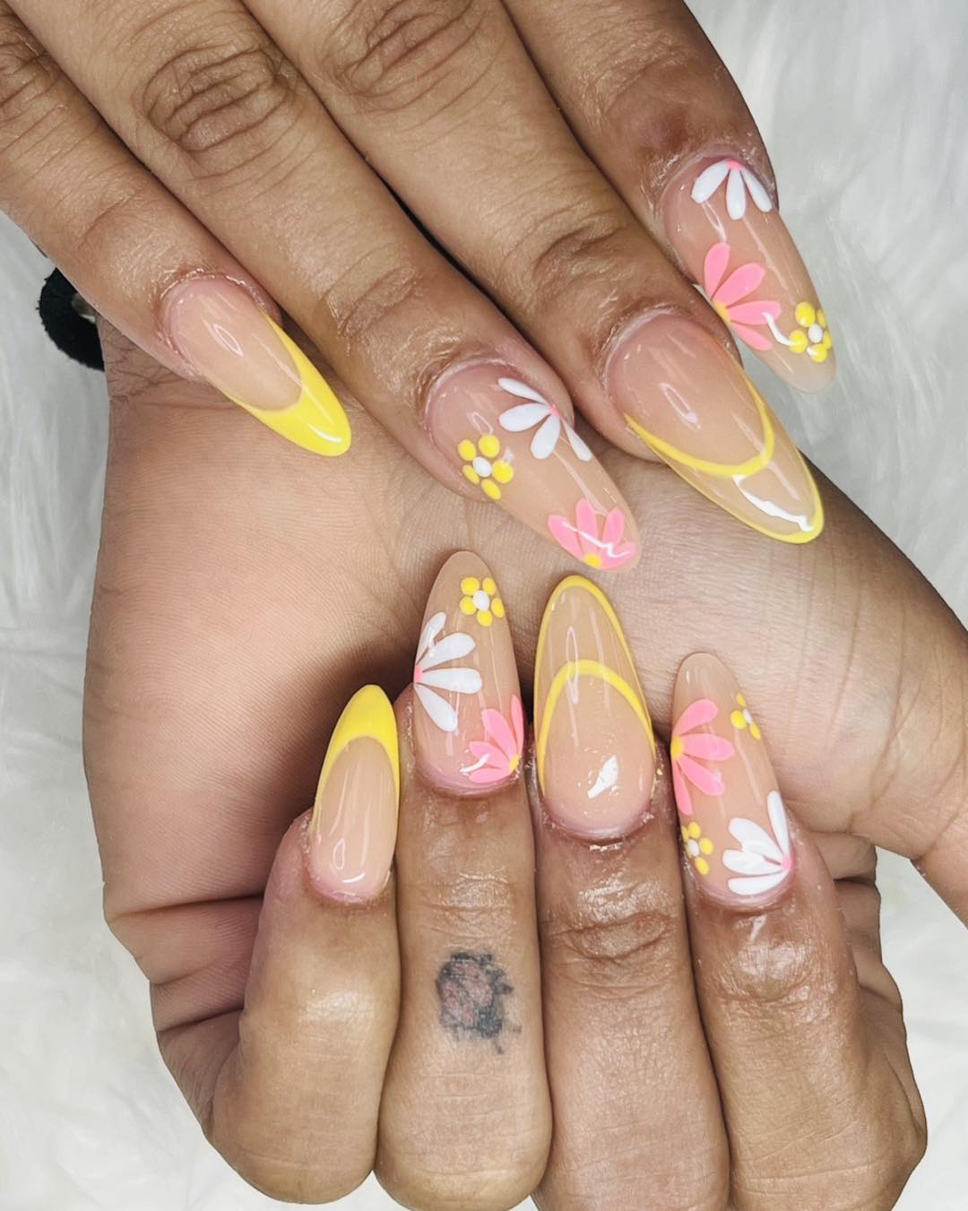 Yellow floral nail art with almond shape and bright accents