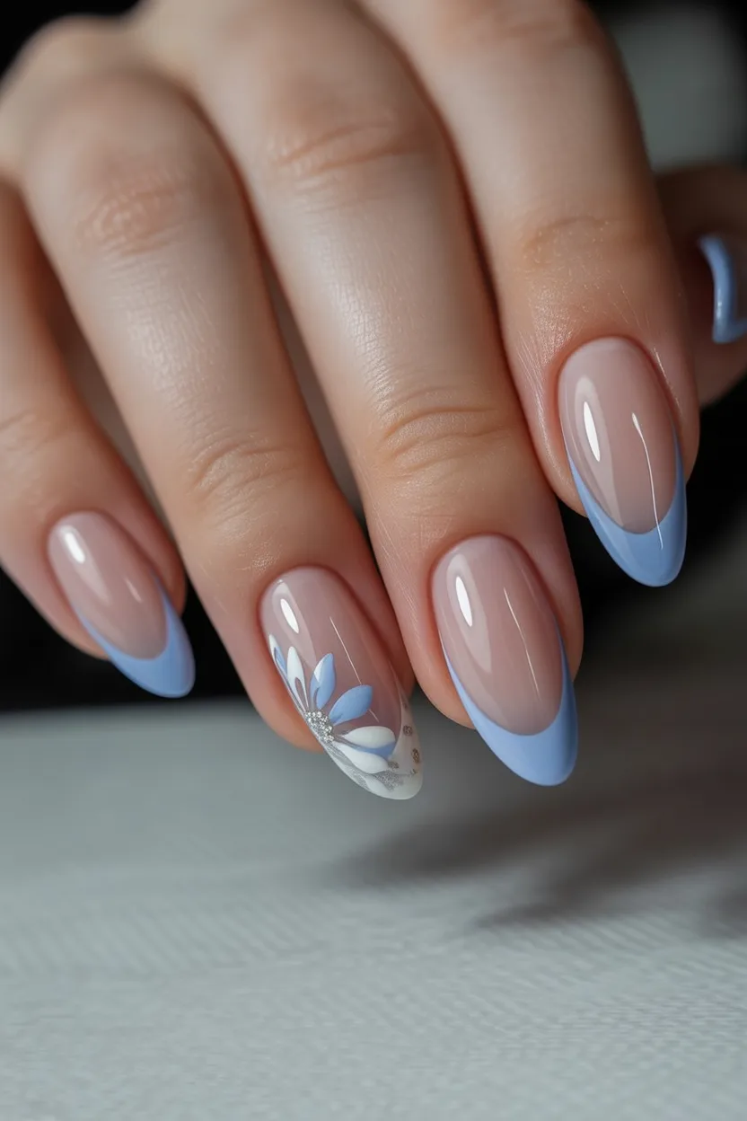 Soft blue French nails with almond shape and floral accents