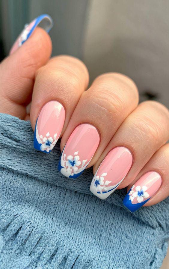 Blue and white floral French tips with pastel pink base.