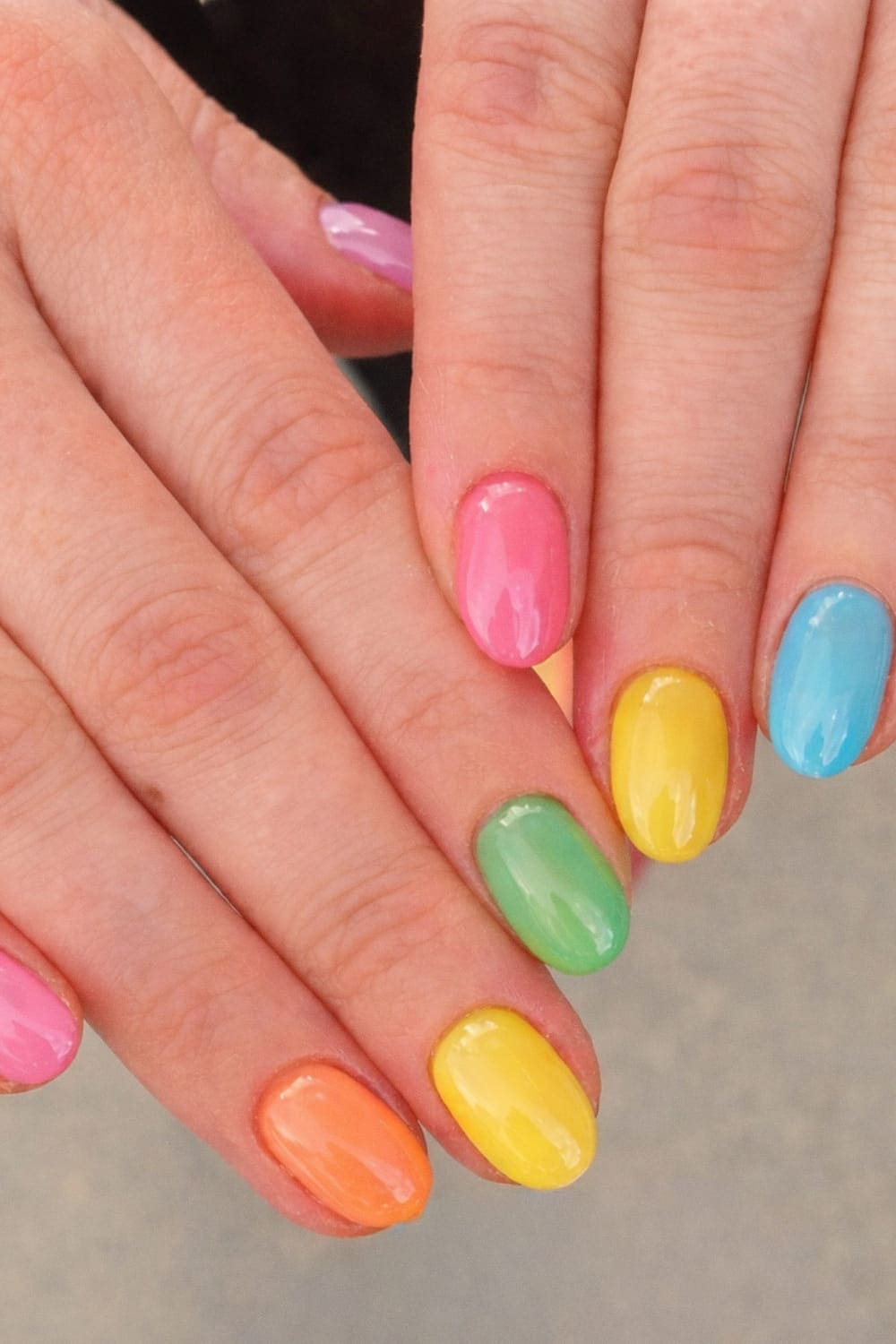 Vibrant rainbow nails on short round nails