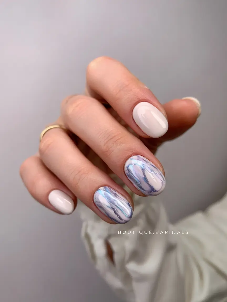 Neutral nails with marble accent, modern chic.