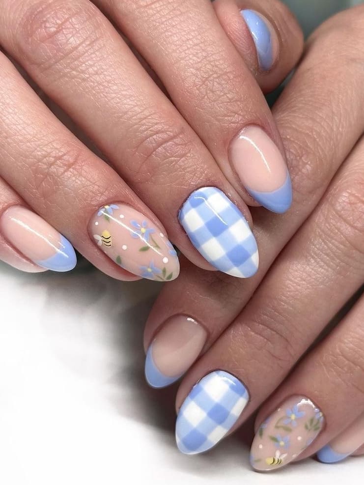 Pastel blue and pink gingham and floral nail art on short almond nails.