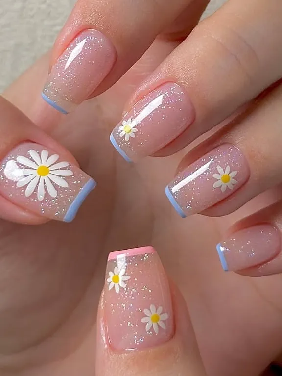 Daisy nail art with glitter and French tips on square nails.