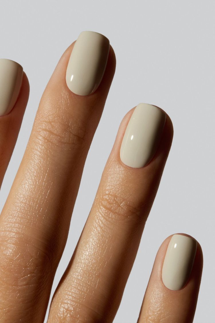 Glossy nude manicure on short round nails.