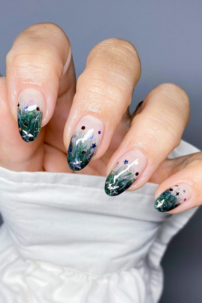 Forest-inspired nail art on almond nails.