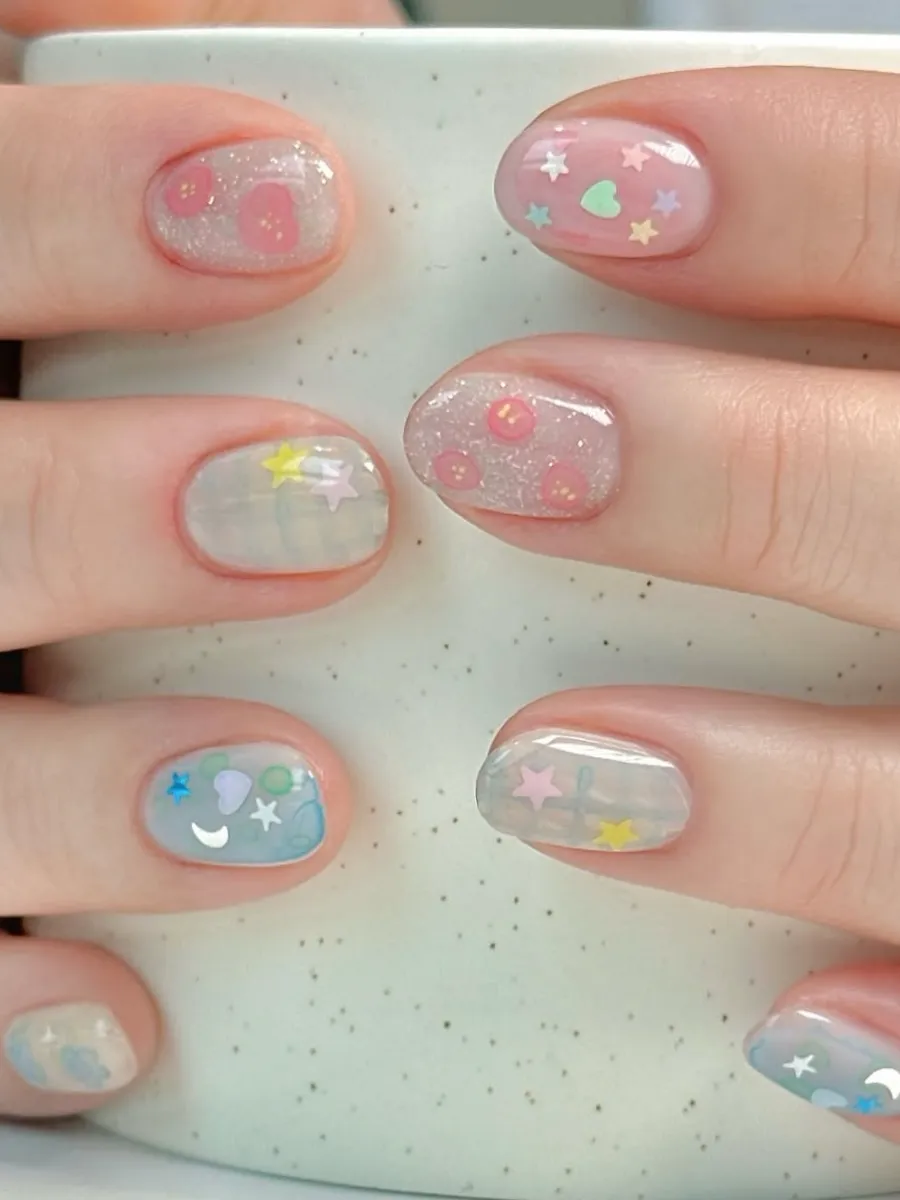 Pastel star and moon nail art on round nails.