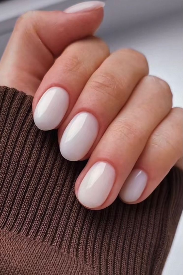 Ivory glossy nails on short oval shape.