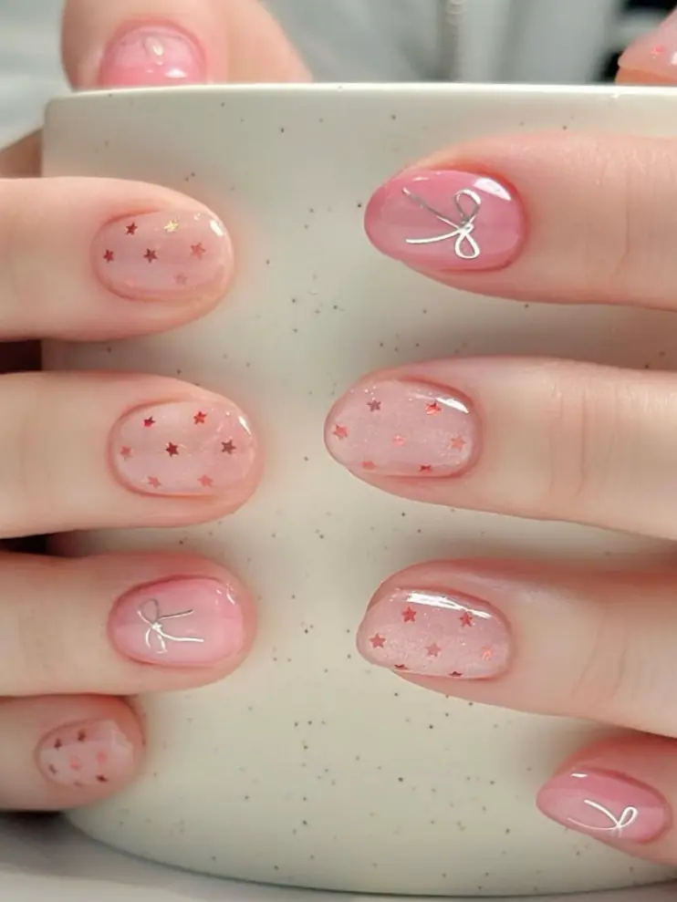 Pink nails with star and bow accents, whimsical spring nails, playful design