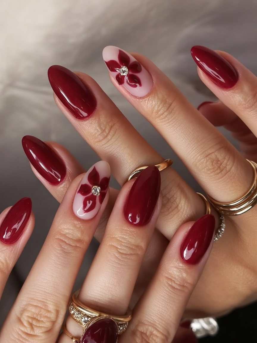 Almond nails with deep red polish and floral design.