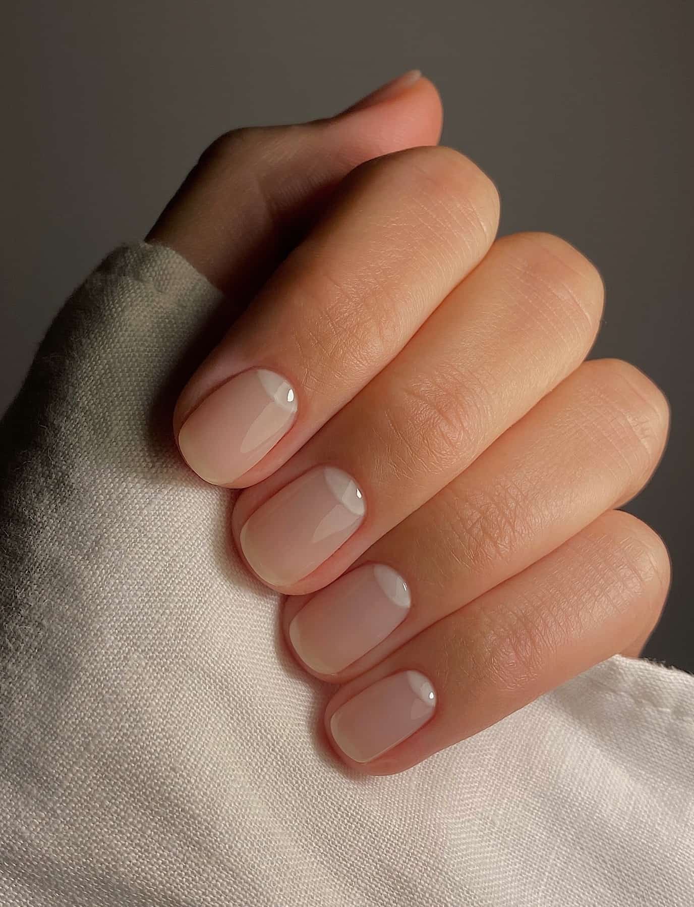 Short square nails with nude polish.