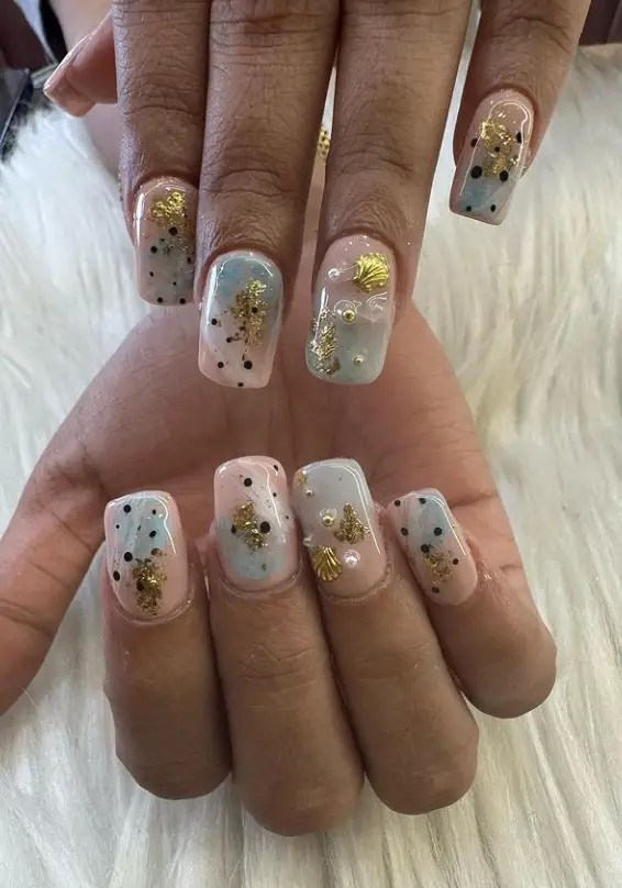 Golden seashell nails, ideal for beach-inspired vacation styles