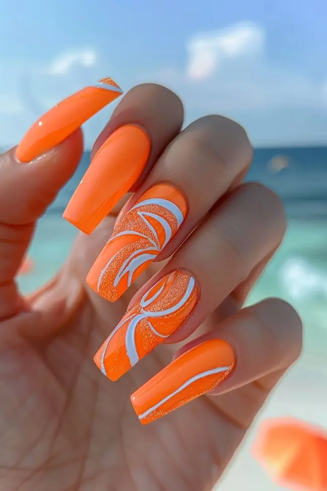 Vibrant orange swirl nails, perfect for energetic vacation styles