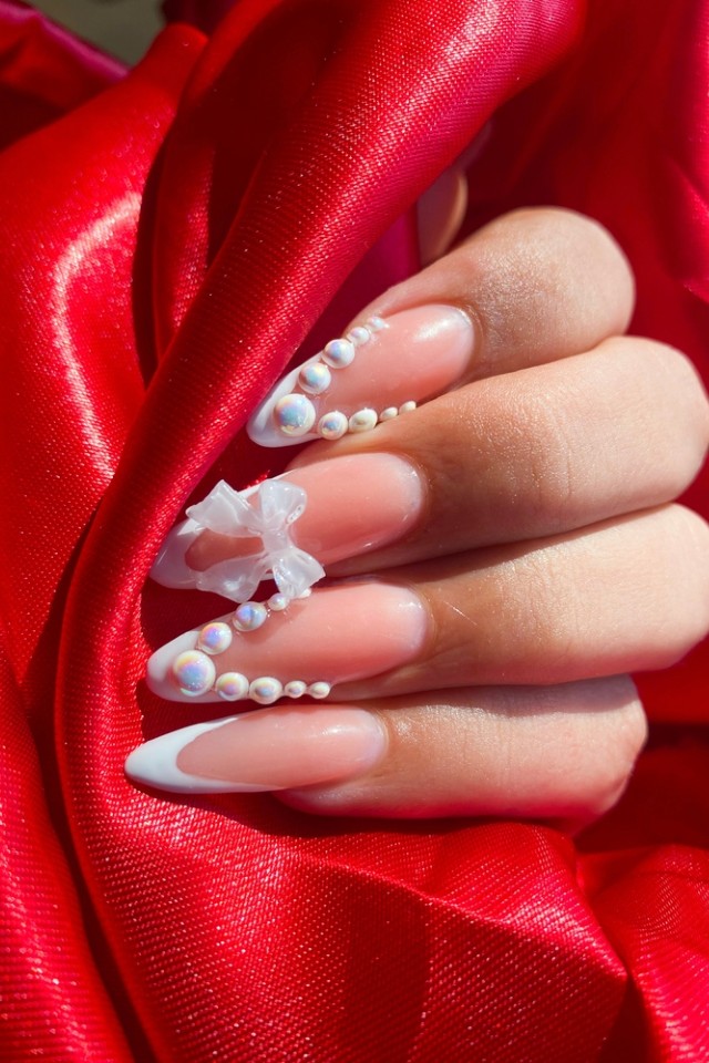 Long almond nails with pearls and embellishments, luxurious bridal style.