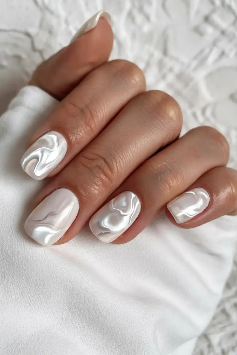 Short nails with white marble design, chic and modern.
