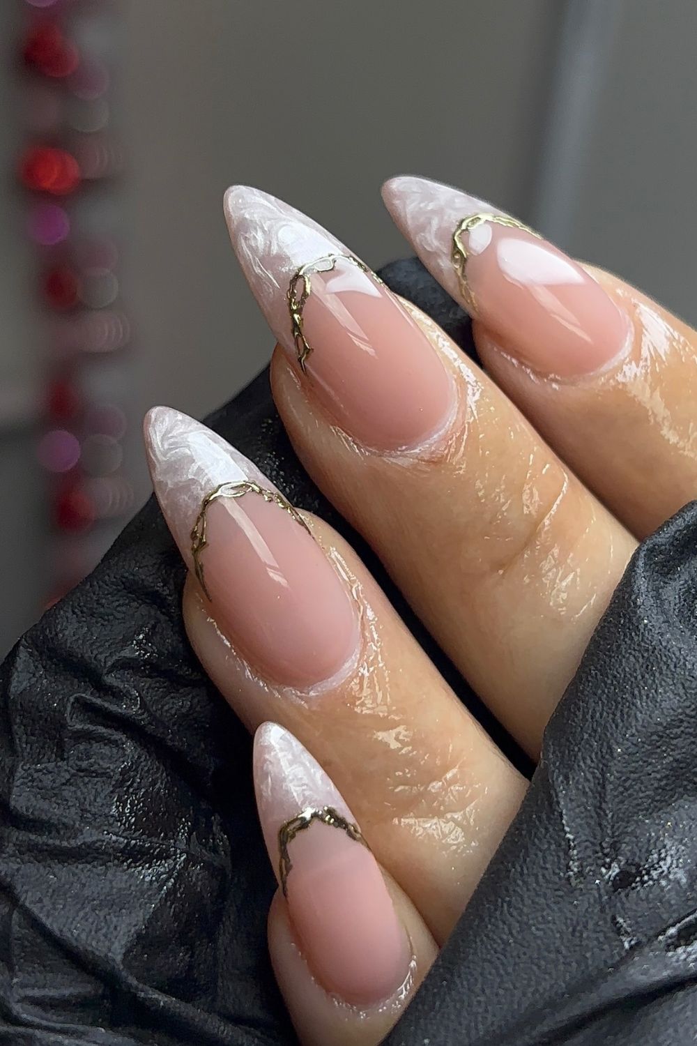 Stiletto nails with marble design and gold accents, luxurious style.
