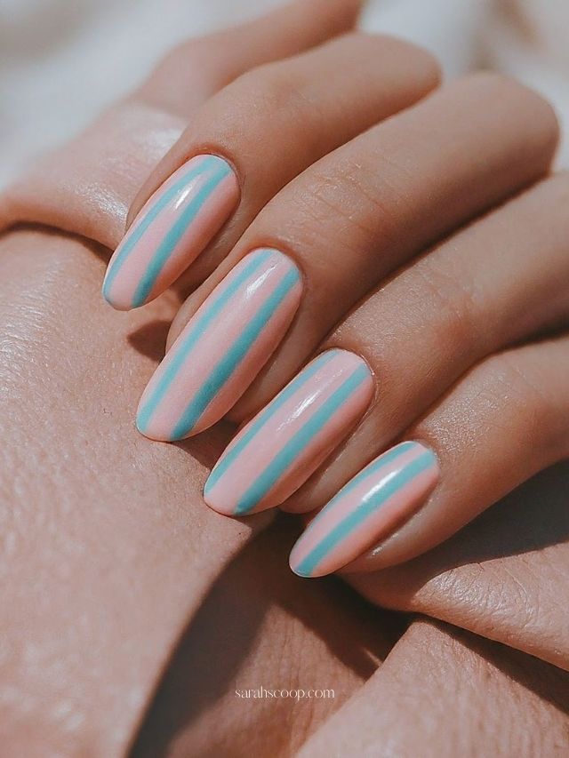 Striped pastel nails with pink and blue, candy-inspired.