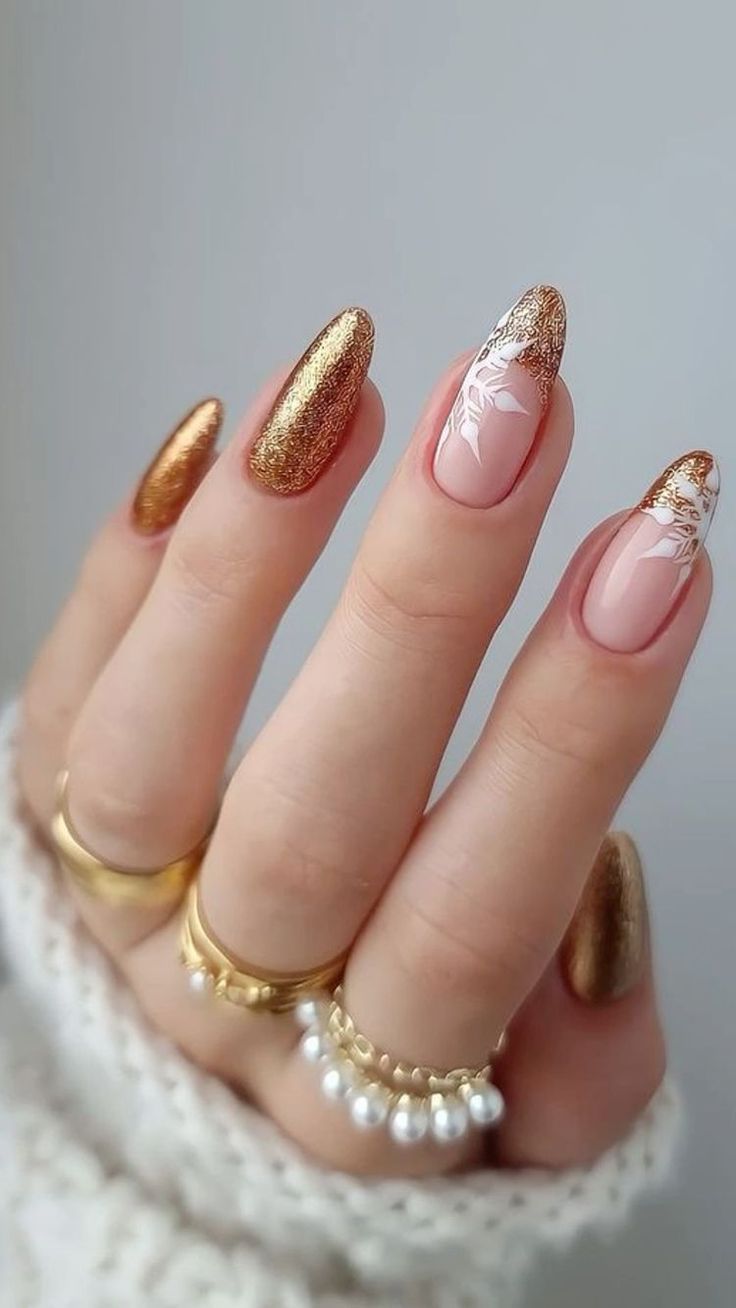 Bronze glitter tips with floral accents, elegant almond nails.