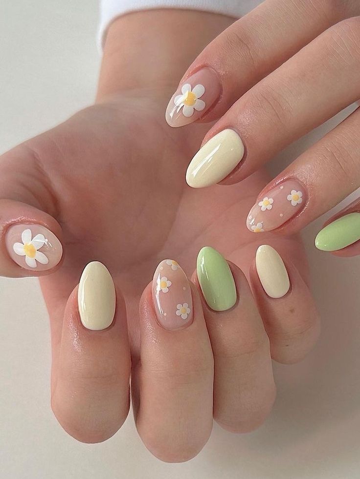 Pastel and green nails with daisy accents.